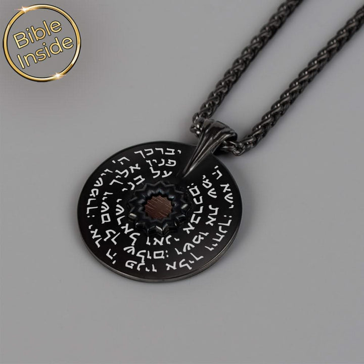 תקריב של ברכת הכהנים באותיות לבנות על תליון שחור
