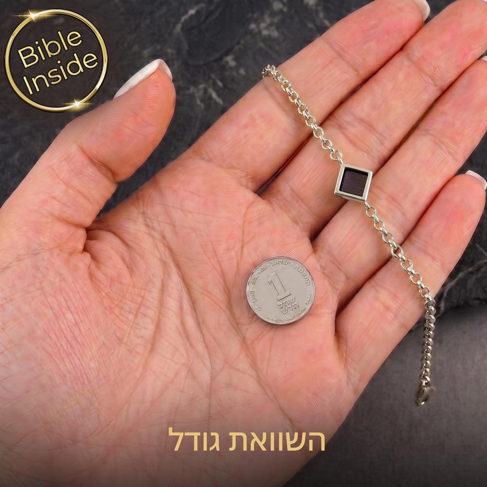 צמיד תנ"ך לאישה בגוון כסף מונח על כף יד לצד מטבע להמחשת הגודל